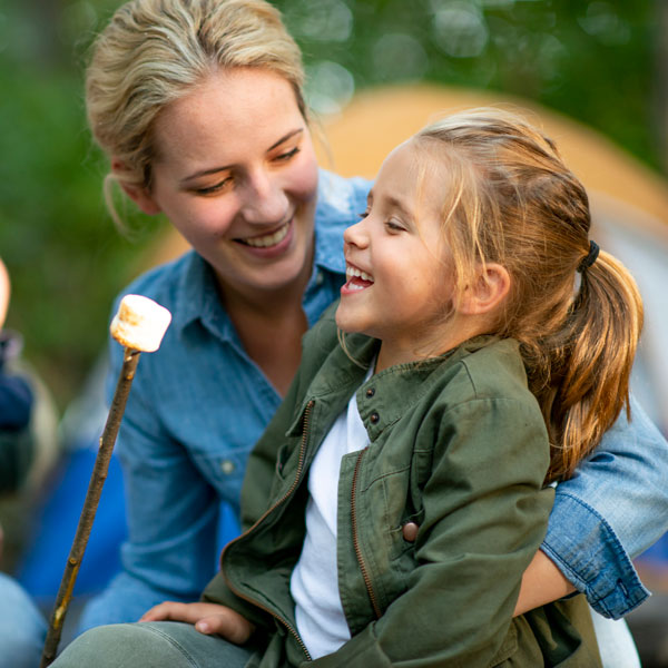 mother and daughter laughing with toasted marshmallow