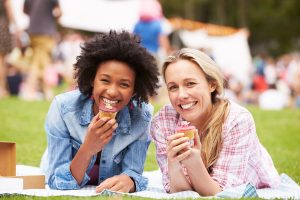 two women eating while laying down